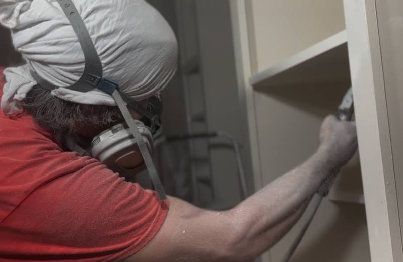ACo. Painting spraying kitchen cabinet boxes with a fine-finish sprayer on a recent job